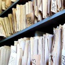 old files on shelves found during insurance archeology