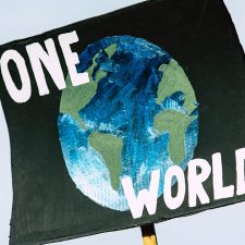 Picture of protest sign with the words one world on it