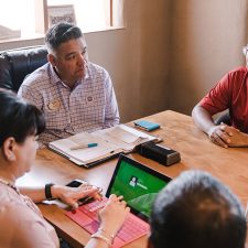Drycleaner sitting at table negotiating sale of property and business