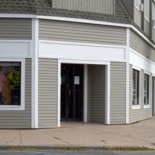Drycleaner in a strip mall with a for sale sign