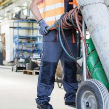 worker pushing drycleaner equipment on hand truck
